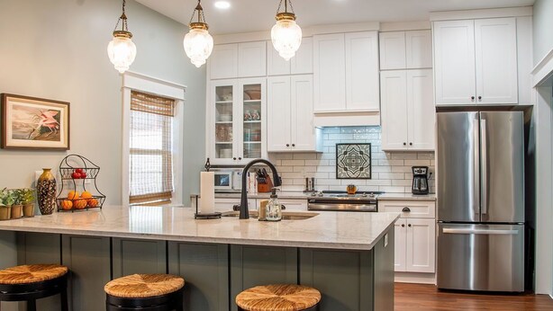 A modern kitchen with white cabinets, a stainless steel refrigerator, and a large island with stools. - Walk to Historic St. Augustine | Guest Favorite (St. Augustine)