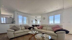 A modern living room with a beige sofa, two glass coffee tables, and a wooden floor. - Villa in Estepona with panoramic views and a private pool. (Estepona)