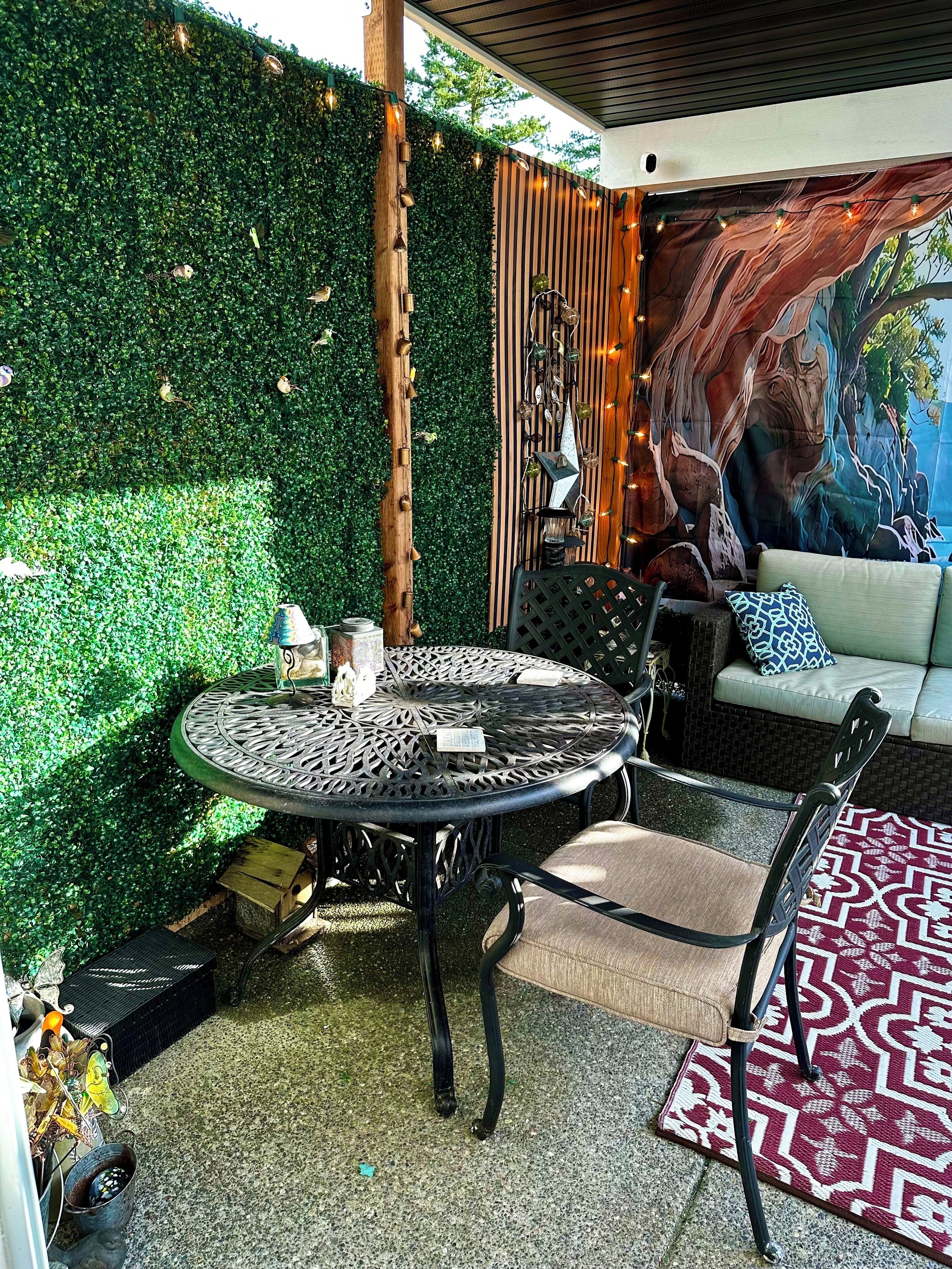 A patio area with a round metal table, chairs, and a sofa.