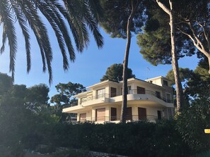 A two-story building with balconies, surrounded by trees and greenery. - Listed villa at Cap d'Antibes, facing the sea (Antibes)
