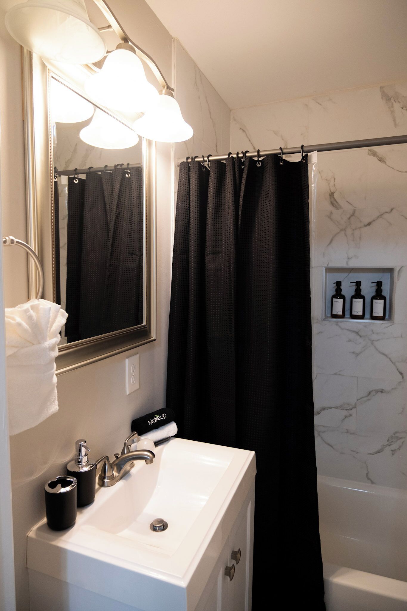 A bathroom with a white sink, a mirror, and a shower curtain.