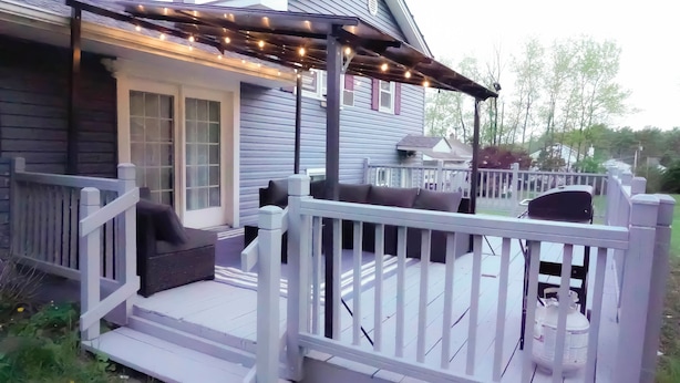 A covered deck with outdoor seating and string lights. - Cozy River Valley Family Retreat w/ Fireplace, Games & Serene Deck (Sparrow Bush)