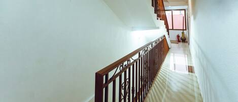 A staircase with a wooden railing leading to a landing.