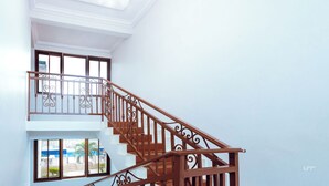 A staircase with ornate railings leading to a balcony. - Excelsa Lodge (Ejisu)