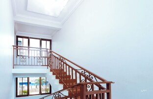 Una escalera con barandales ornamentales que conduce a un balcón.