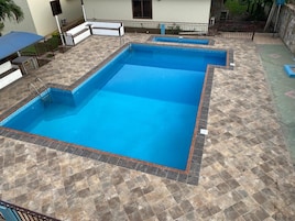 Una piscina rectangular con un borde de baldosas alrededor.