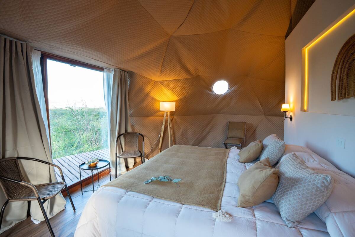 Une pièce comprenant un lit, une chaise, une table et une lampe.