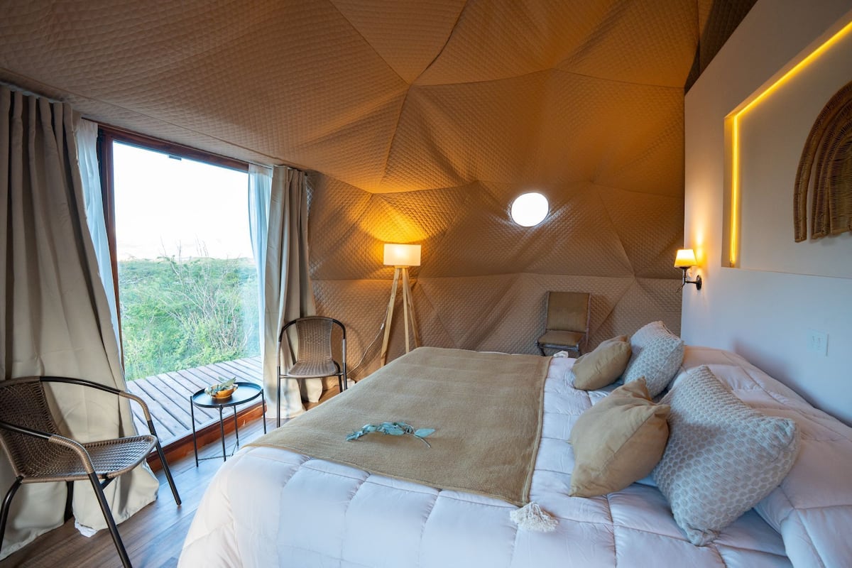 Une pièce comprenant un lit, une chaise, une table et une lampe.