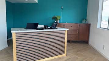 A modern office space with a wooden desk, a laptop, and a plant.
