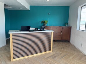 Un ambiente ufficio moderno con una scrivania in legno, un portatile e una pianta.