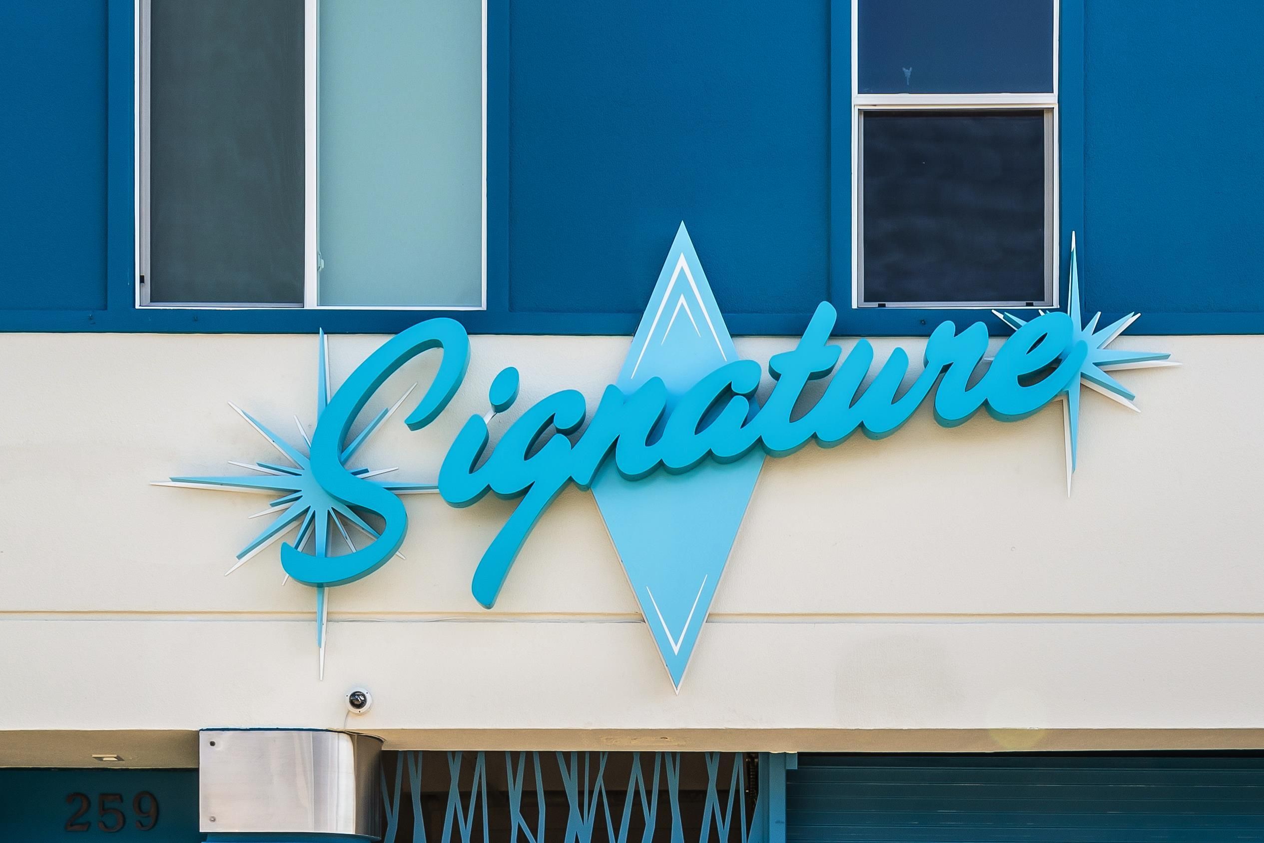 A building with a sign that reads 'Signature' in a stylized font.