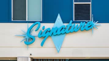 A building with a sign that reads 'Signature' in a stylized font.