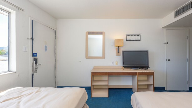 A hotel room with two beds, a desk with a television, a mirror, and a lamp. - Signature Inn Socorro (Socorro)