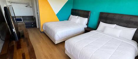 Une chambre d’hôtel avec deux lits, une télévision et un miroir.