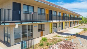 A motel with a two-story structure, featuring a balcony on the upper floor, a 'Pull' sign indicating the entrance, and a 'No Smoking' sign. - Signature Inn Socorro (Socorro)