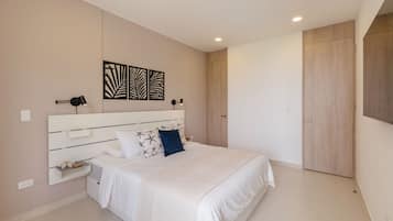 A modern bedroom with a large bed, bedside tables, a wardrobe, and decorative wall art.