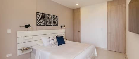 A modern bedroom with a large bed, bedside tables, a wardrobe, and decorative wall art.