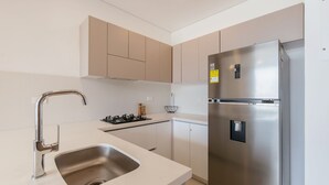 Une cuisine moderne équipée d’un réfrigérateur en acier inoxydable, d’une cuisinière à gaz et d’un évier.