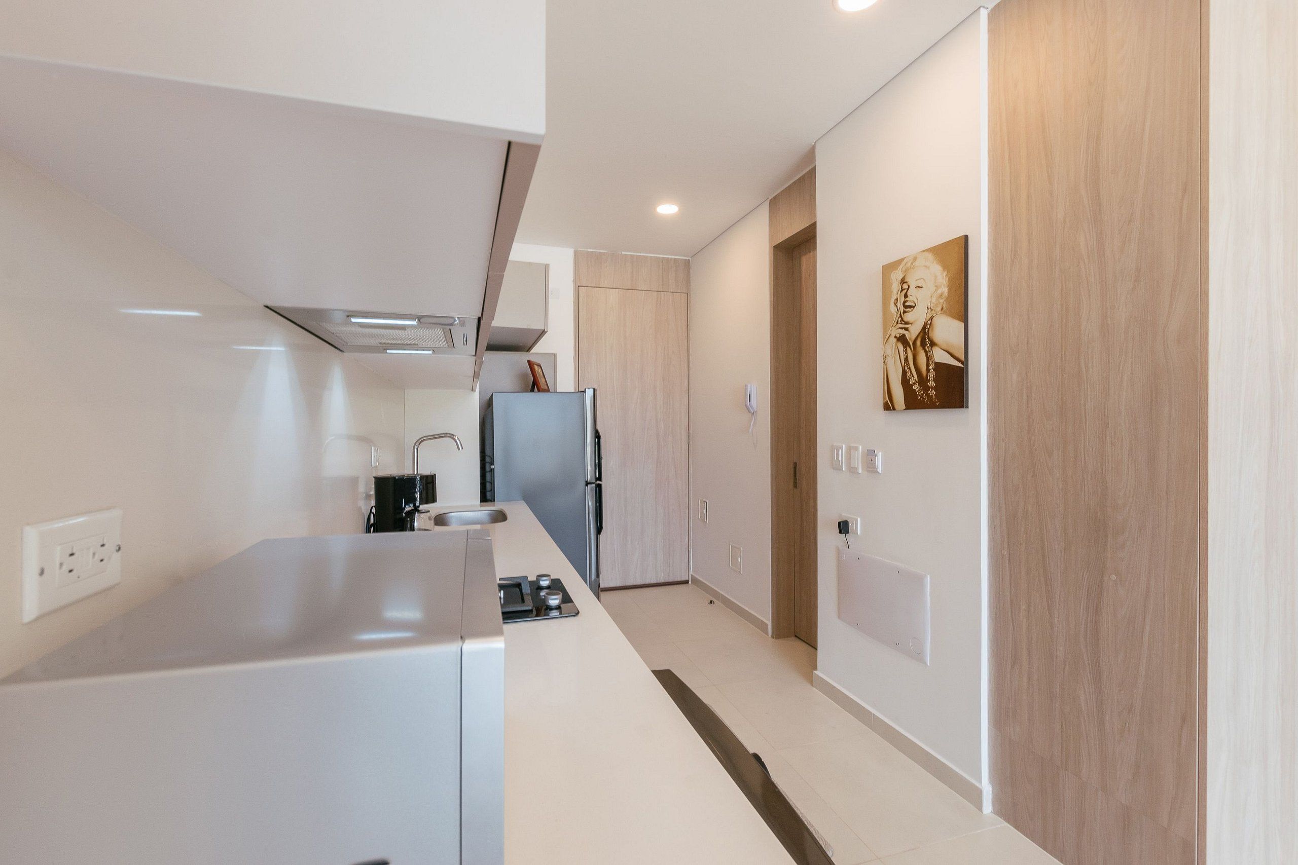 A modern kitchen with a built-in oven, a sink, and a refrigerator.