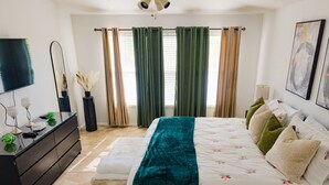 Une chambre à coucher avec un lit, une commode et un téléviseur.