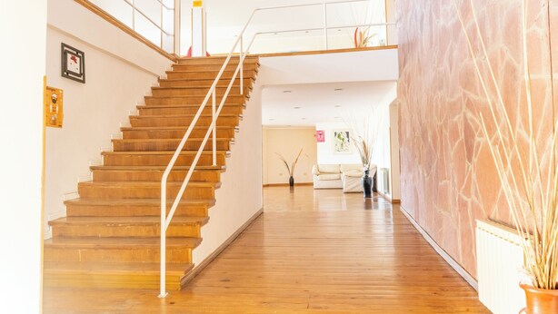 A staircase with wooden steps and white railings leading to a higher floor. - ORIPLATA (Caviahue)