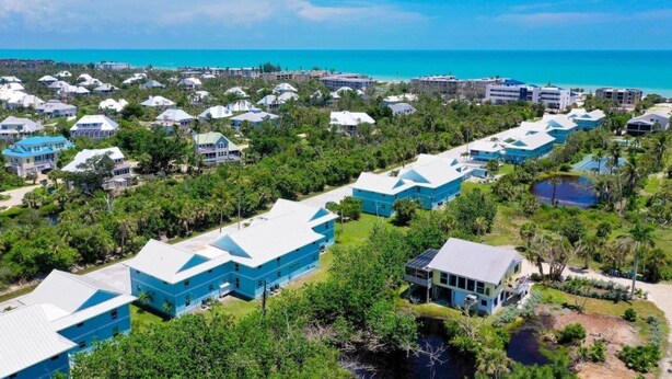 Ein Resort mit mehreren Gebäuden, einem Strand und freiem Blick auf den Ozean.