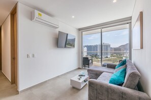 A modern living room with a flat-screen TV, a sofa, and a coffee table. - U-GO Edificio Salguero Sunset (Santa Marta)
