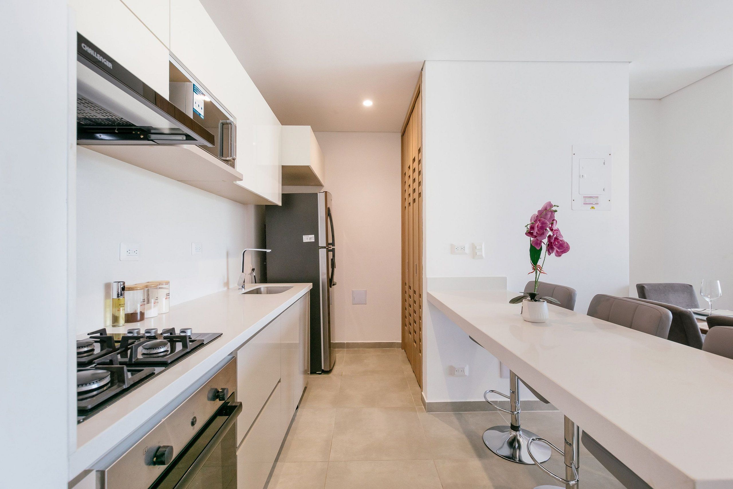 A modern kitchen with a gas stove, oven, and a refrigerator.