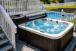 A hot tub on a wooden deck with a white railing and a pool in the background. - Pool-Fenced Yard-Pool Table-Sleeps 10 (Fairfield)