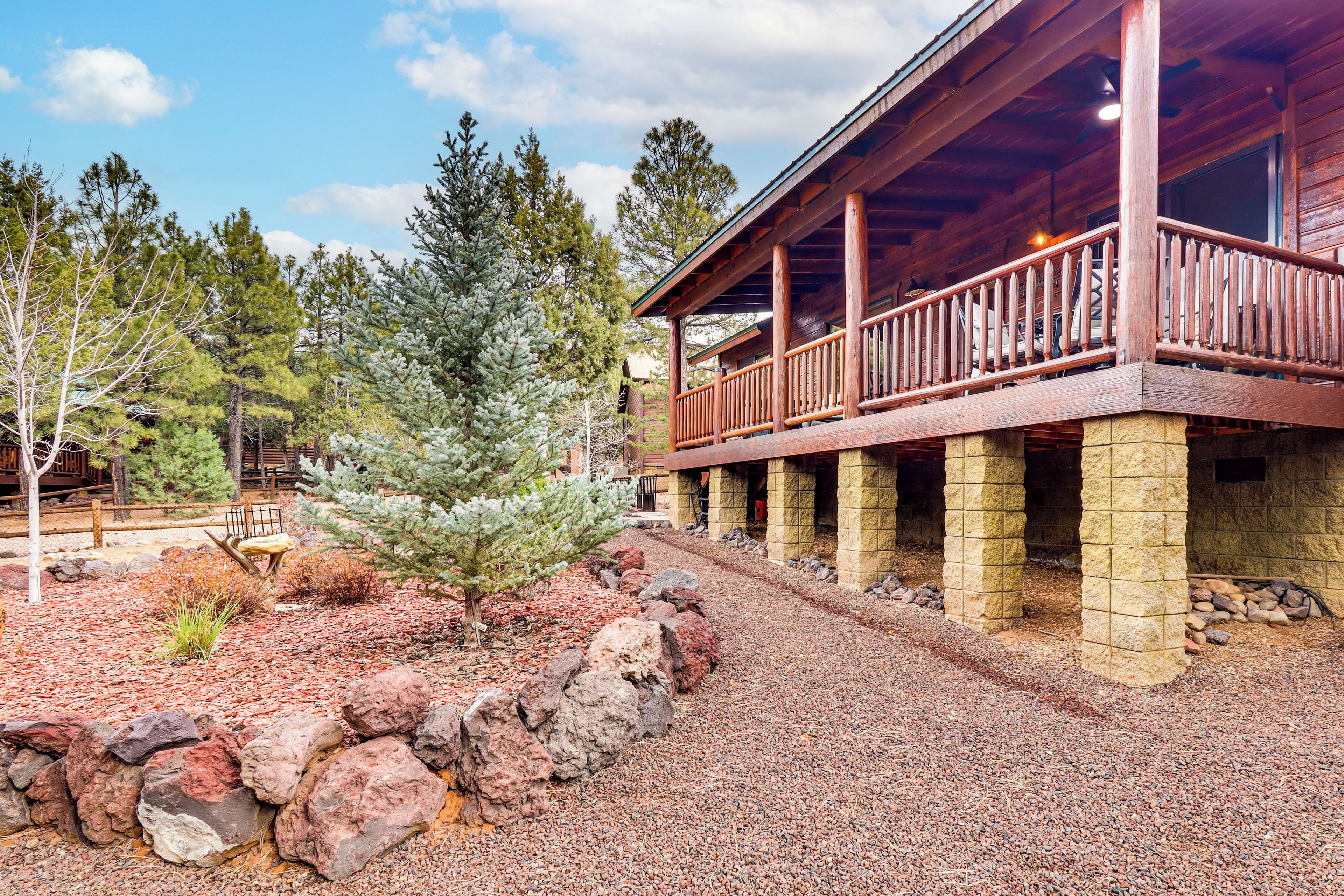 A wooden cabin with a covered porch and stone pillars.