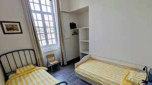 A room with two beds, a window, a radiator, a chair, and a wardrobe. - La Bonne Ecole - La Marelle Vacation Rental - Sleeps 7 - 20 min from Puy du Fou - (Les Landes-Genusson)