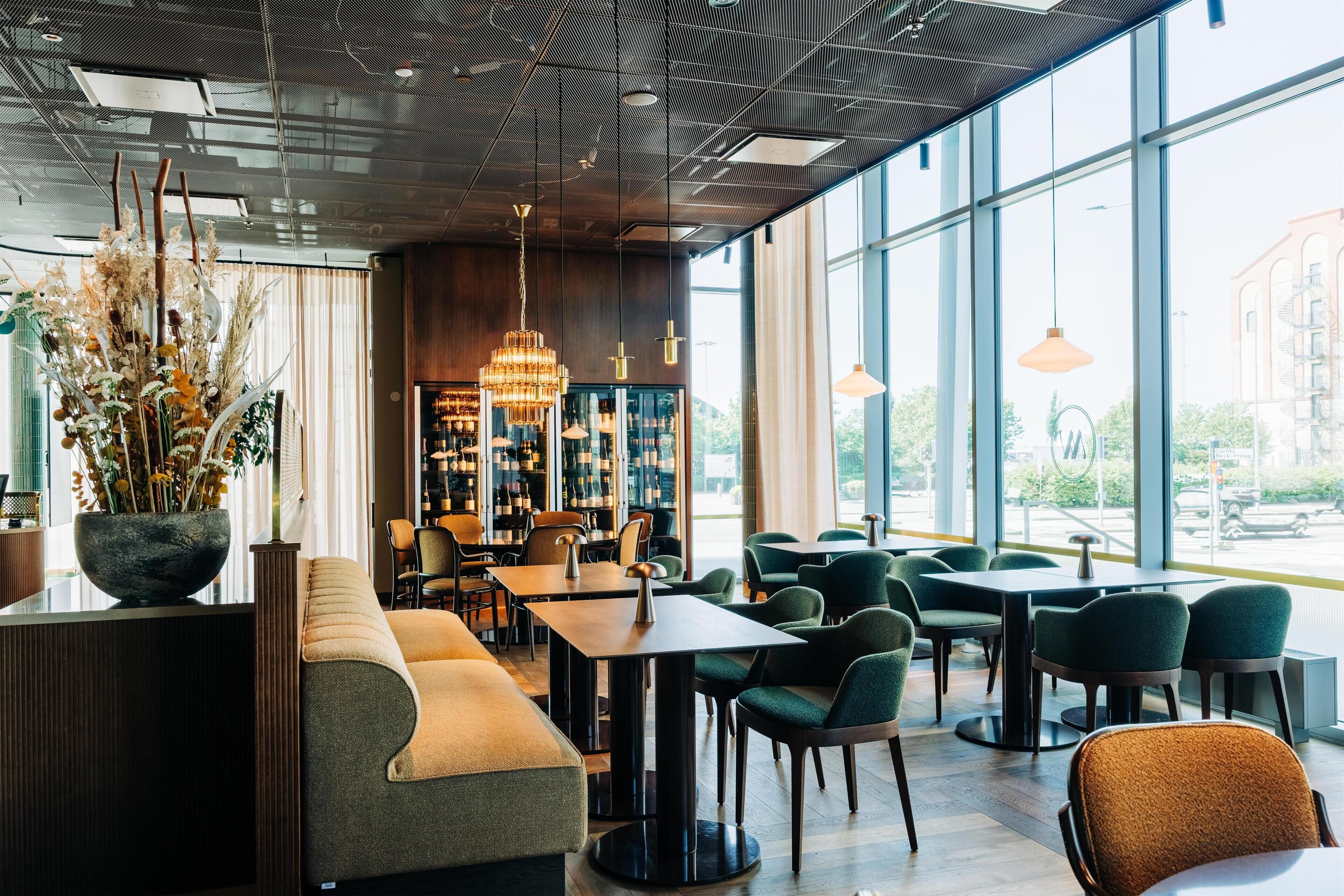 Um interior moderno com área de bar, assentos e amplas janelas.