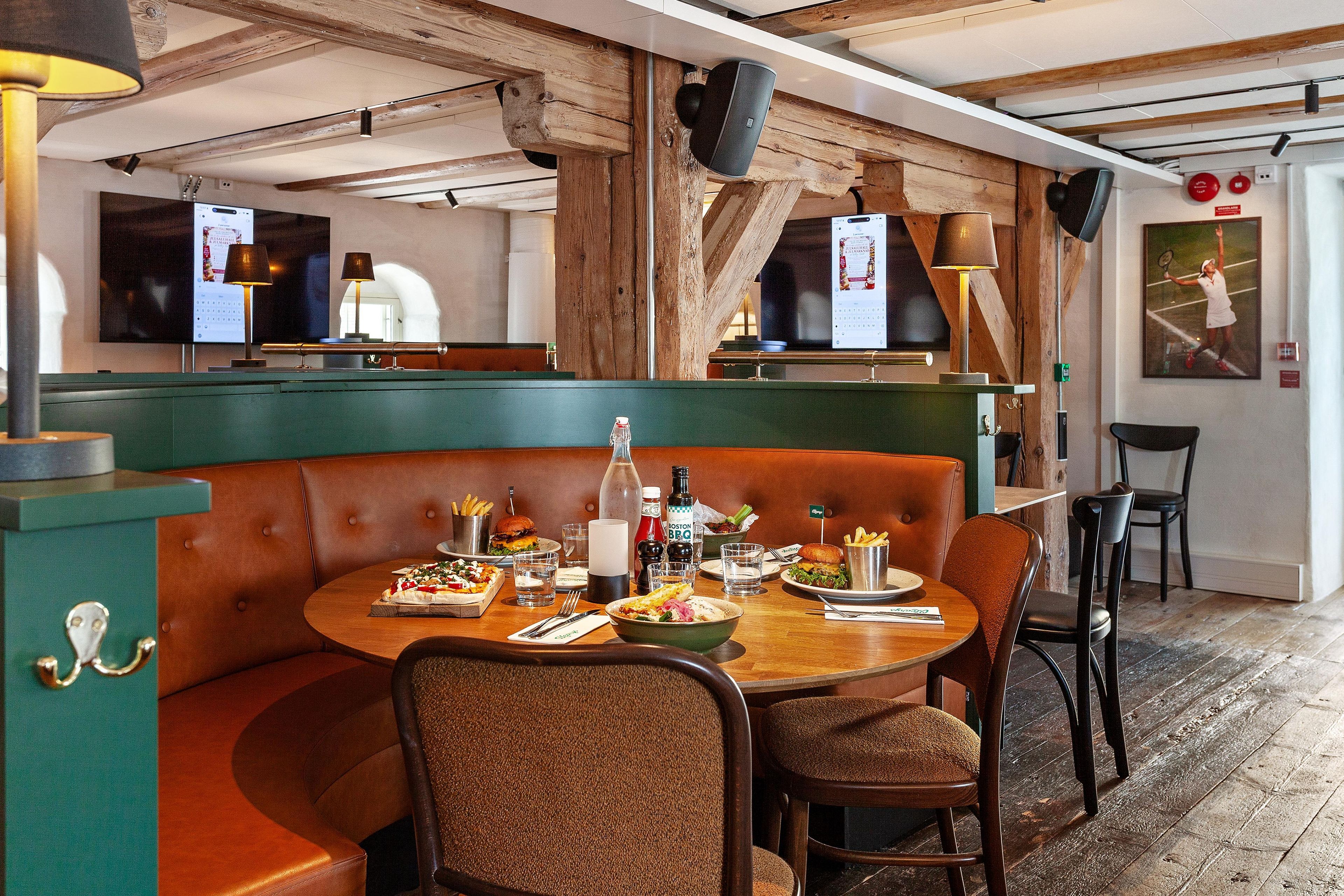Un restaurant avec des banquettes, un comptoir et une affiche sportive accrochée au mur.