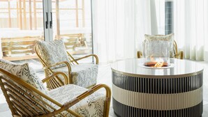 A room with a round table, wicker chairs, and a view through large windows. - Willow, Worldhotels Crafted (Trelleborg)