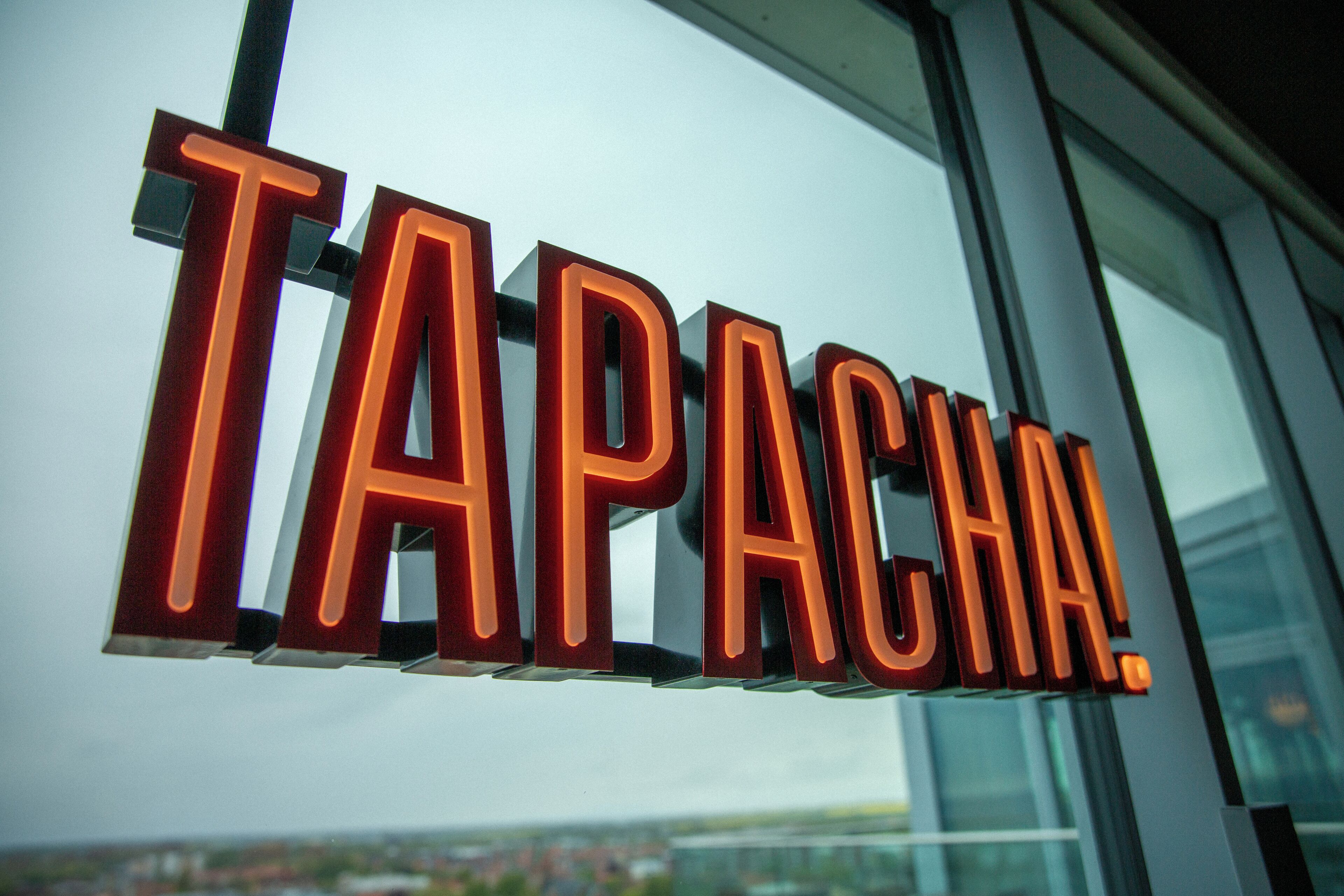 A sign with the word 'TAPACA' in bold, illuminated letters.