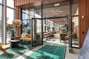 A hotel reception area with a modern design, featuring a reception desk, seating area, and large windows allowing natural light. - Willow, Worldhotels Crafted (Trelleborg)