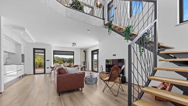 A spacious living area with a modern kitchen, a staircase with a metal railing, and a view of the outdoors. - Villa Enja in tranquille village with heated salted pool (Vintijan)