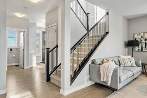 Stairway between the main floor and upper floor. - The Empress | Fire Pit | Dbl Garage | Office | BBQ (Airdrie)