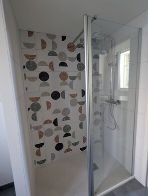 Regadera, secadora de cabello, papel de baño 