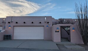 Un bâtiment moderne doté d’une porte de garage, d’une petite entrée avec une enseigne et surplombant un ciel dégagé.