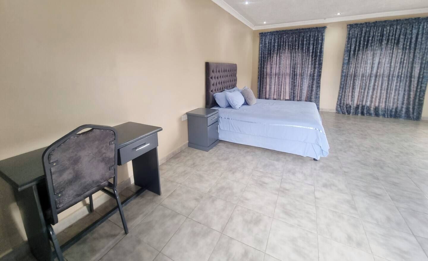 Une chambre à coucher avec un lit, un bureau et une chaise.