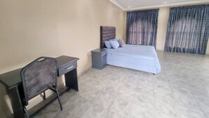 Um quarto com uma cama, uma escrivaninha e uma cadeira.