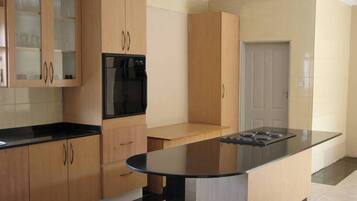 A kitchen with wooden cabinets, a black countertop, and a built-in oven.