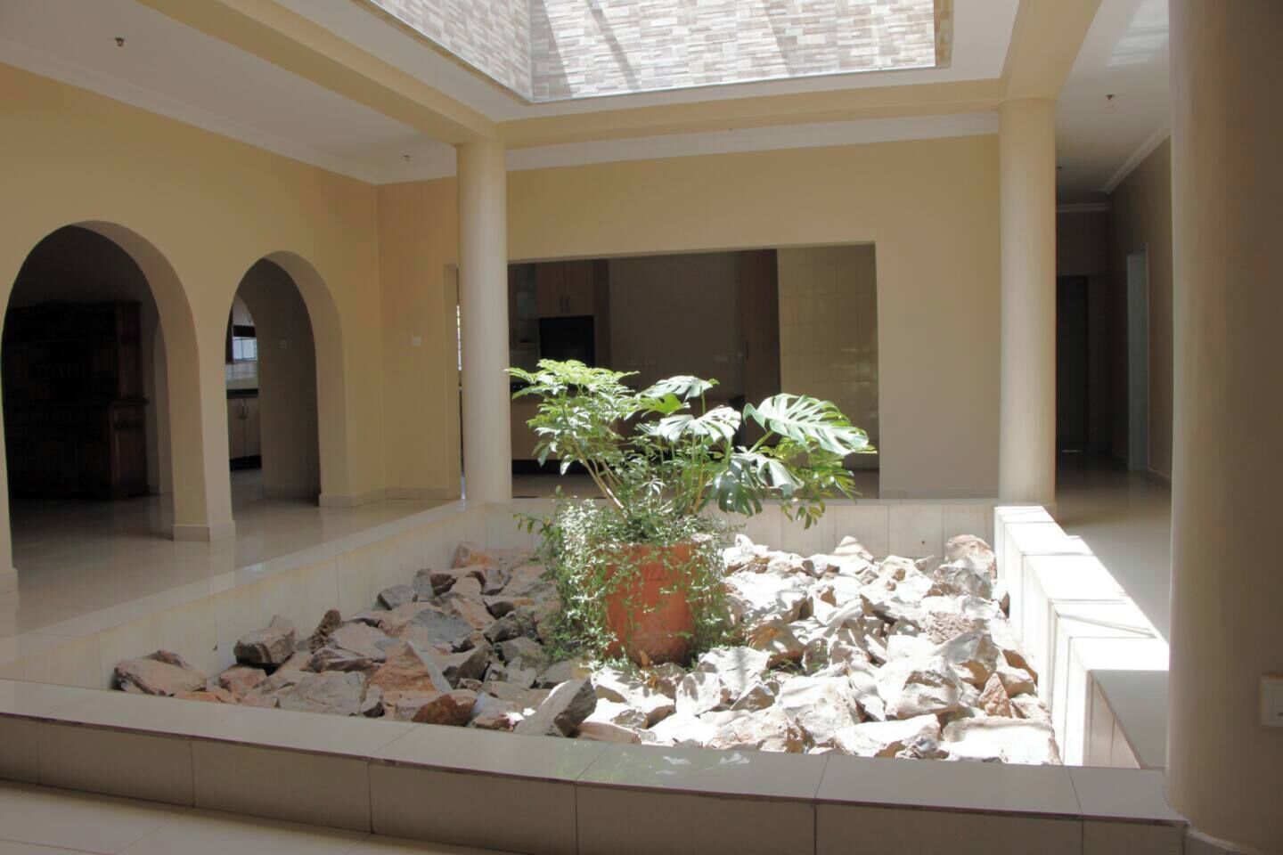 A spacious atrium with a central rock garden and a potted plant.