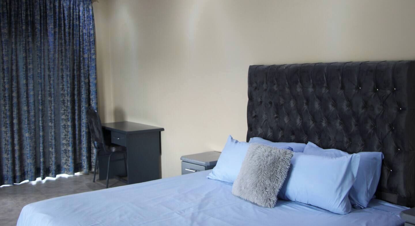 Een hotelkamer met een bed, een bureau en een stoel.