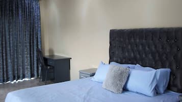 Une chambre d’hôtel avec un lit, un bureau et une chaise.