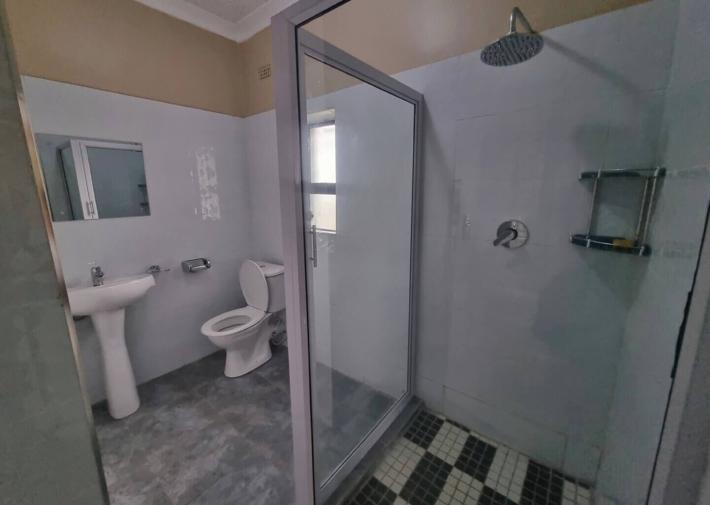 A bathroom with a toilet, sink, and shower.