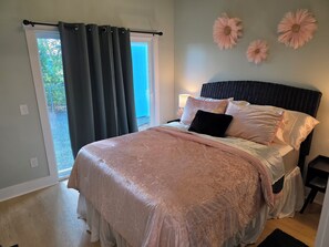 Un dormitorio con una cama, una ventana con cortinas y una pared decorada con tres motivos florales.