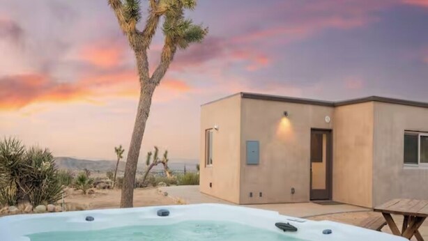 A modern house with a hot tub in the foreground and a desert landscape in the background. - Juniper House - Desert Retreat near JTNP - Stargazing, Views & Spa (Joshua Tree)