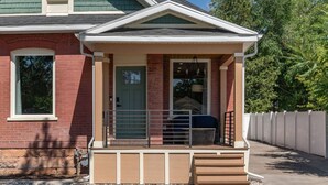 Una casa con un portico, una porta e una finestra piccola.